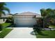 Exterior angle of a single-Gathering home with lush landscaping and a two-car garage at 9736 Sage Creek Dr, Ruskin, FL 33573
