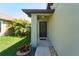 View of the front door entrance with a dark wood door and manicured garden at 9736 Sage Creek Dr, Ruskin, FL 33573