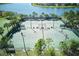 Aerial view of the community tennis courts surrounded by lush landscaping and views of the lake at 9736 Sage Creek Dr, Ruskin, FL 33573