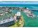 Gorgeous aerial view of a waterfront building featuring turquoise water, a marina, and scenic coastal views at 1 Key Capri # 301E, Treasure Island, FL 33706