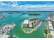 Amazing aerial view of waterfront buildings with docks, a pool, and tennis courts surrounded by scenic waterways at 1 Key Capri # 301E, Treasure Island, FL 33706