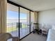 Balcony with table and chairs overlooking the water is visible through the sliding glass door from the bedroom at 1 Key Capri # 301E, Treasure Island, FL 33706