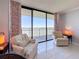 Inviting balcony area offers stunning water views, comfortable chairs, and stylish curtains for a relaxing retreat at 1 Key Capri # 301E, Treasure Island, FL 33706