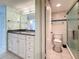 Bathroom featuring white cabinets, granite counters, and white tile floors, plus toilet and shower visible at 1 Key Capri # 301E, Treasure Island, FL 33706