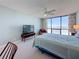 Well-lit bedroom featuring a comfortable bed, a TV, and a fan for added comfort at 1 Key Capri # 301E, Treasure Island, FL 33706