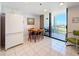 Condo kitchen with a wooden table, tile floors, white cabinets, and balcony access with water view at 1 Key Capri # 301E, Treasure Island, FL 33706