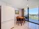 Condo kitchen with a wooden table, tile floors, white cabinets, and balcony access showcasing the water view at 1 Key Capri # 301E, Treasure Island, FL 33706