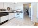 Bright kitchen with white cabinets, tile floor, and stainless-steel appliances at 1 Key Capri # 301E, Treasure Island, FL 33706