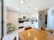 Bright condo kitchen with white cabinets, and sleek appliances adjacent to the dining area and balcony access at 1 Key Capri # 301E, Treasure Island, FL 33706