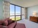 Comfortable living room with a view of the water from the large picture window and a cozy couch with throw pillows at 1 Key Capri # 301E, Treasure Island, FL 33706