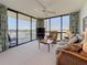 Living room with neutral carpet, fan, balcony access and views at 1 Key Capri # 301E, Treasure Island, FL 33706