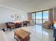 Bright living room with tile floor, comfortable seating, and sliding glass doors to a balcony overlooking the water at 1 Key Capri # 301E, Treasure Island, FL 33706
