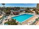 Community pool features inviting lounge chairs and tables and is surrounded by tropical foliage at 1 Key Capri # 301E, Treasure Island, FL 33706