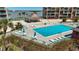 Inviting community pool with a poolside bar, lounge chairs, and scenic waterfront views at 1 Key Capri # 301E, Treasure Island, FL 33706