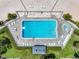 Overhead view of a pool and hot tub, with many lounge chairs, tables, umbrellas and tropical foliage at 1 Key Capri # 301E, Treasure Island, FL 33706