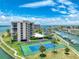 Aerial view of a tennis court adjacent to a multi-Gathering property and boat docks at 1 Key Capri # 301E, Treasure Island, FL 33706