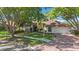 Charming single-story home with lush landscaping, a brick driveway, and mature trees in a well-maintained yard at 1006 Chatham Ct, Safety Harbor, FL 34695