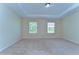 Bright bedroom featuring large windows, neutral carpet, and a tray ceiling at 10144 Arbor Run Dr # 122, Tampa, FL 33647