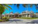 Exterior of a clubhouse featuring manicured lawns and palm trees at 10144 Arbor Run Dr # 122, Tampa, FL 33647