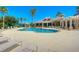 A luxurious community pool offers plenty of seating, poolside umbrellas, and lush landscaping for relaxation at 10144 Arbor Run Dr # 122, Tampa, FL 33647
