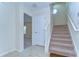 Bright foyer featuring tiled flooring, a carpeted staircase, and an open doorway to another room at 10144 Arbor Run Dr # 122, Tampa, FL 33647