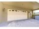 A two car garage with beige door and brick paver driveway and exterior lighting at 10144 Arbor Run Dr # 122, Tampa, FL 33647