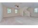 Large living room with carpet flooring, windows, and staircase access at 10144 Arbor Run Dr # 122, Tampa, FL 33647