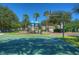 Community playground and basketball court with green surface, surrounded by trees and blue sky at 10144 Arbor Run Dr # 122, Tampa, FL 33647