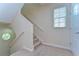 Carpeted staircase leading to the upper level, with a window providing natural light at 10144 Arbor Run Dr # 122, Tampa, FL 33647