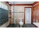 Tiled bathroom featuring a glass shower, pebble accents, and a door leading to a hallway at 112 Gause Dr, Venice, FL 34293