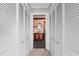Hallway features louvered closet doors, leading to an eclectic bathroom with decorative tile and stone at 112 Gause Dr, Venice, FL 34293