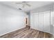 Bedroom featuring laminated wood flooring, a ceiling fan, and double door closet at 112 Gause Dr, Venice, FL 34293