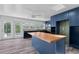 Bright kitchen boasts butcher block counters, blue cabinets, ceiling fan, and stainless steel appliances at 112 Gause Dr, Venice, FL 34293