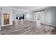 An open-concept living room and view to the kitchen, barn doors, and wood floors at 112 Gause Dr, Venice, FL 34293