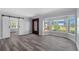 Living room with bay window, barn door, wood-look flooring, and front entry door at 112 Gause Dr, Venice, FL 34293