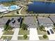 A house with solar panels is showcased in an aerial view alongside nearby community amenities and houses at 11416 Carlton Fields Dr, Riverview, FL 33579
