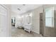 Bright and airy bathroom with double vanities, a walk-in shower, and neutral tile flooring at 11416 Carlton Fields Dr, Riverview, FL 33579