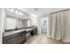 Bathroom featuring double sinks, dark cabinets, granite countertops, and tile flooring at 11416 Carlton Fields Dr, Riverview, FL 33579