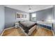 Modern bedroom featuring a large window, gray walls, and bright hardwood flooring at 11416 Carlton Fields Dr, Riverview, FL 33579