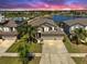 Beautiful two-story home with a well-manicured lawn, three-car garage, and a glimpse of a lake view at 11416 Carlton Fields Dr, Riverview, FL 33579