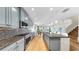 Modern kitchen features sleek blue cabinets, granite countertops, and stainless steel appliances, open to the living area at 11416 Carlton Fields Dr, Riverview, FL 33579