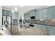Beautiful kitchen with granite countertops, blue cabinets, mosaic backsplash, and stainless steel appliances at 11416 Carlton Fields Dr, Riverview, FL 33579
