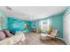 Inviting living room with coastal decor, bright blue accent wall, and hardwood floors at 11416 Carlton Fields Dr, Riverview, FL 33579