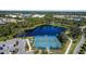 An aerial view showcasing community pickleball courts, pond and lush scenery surrounded by beautiful homes at 12408 Palatka Dr, Venice, FL 34293