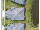 Aerial view of the property showcasing its well-maintained roof, lush landscaping, and proximity to a pond at 12408 Palatka Dr, Venice, FL 34293