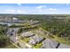 An aerial view shows beautiful homes surrounding a pond in a wooded area with blue skies overhead at 12408 Palatka Dr, Venice, FL 34293