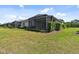 Relaxing backyard with a screened in lanai and lush, manicured lawn at 12408 Palatka Dr, Venice, FL 34293