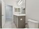 Bathroom features a vanity with grey cabinets, modern fixtures, and tile flooring at 12408 Palatka Dr, Venice, FL 34293