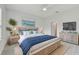 Light-filled bedroom boasts a relaxing color scheme, ceiling fan, and view of palm trees at 12408 Palatka Dr, Venice, FL 34293