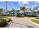 The community's clubhouse with lush landscaping and palm trees sits at the end of a curving driveway at 12408 Palatka Dr, Venice, FL 34293